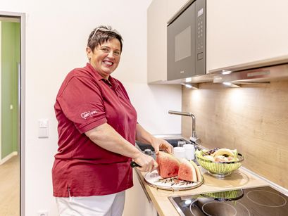 Frau schneidet Wassermelone in der Küche