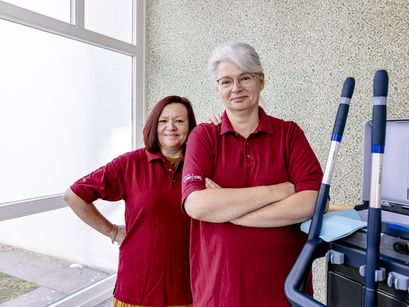Zwei Pflegerinnen schauen glücklich in die Kamera